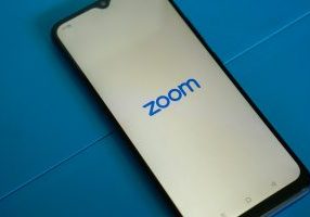 a close up of a cell phone with the zoom logo on it